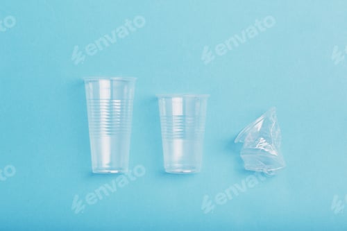 Preview: Plastic cups put in row, over blue background. Collecting plastic waste to recycling. Plastic waste