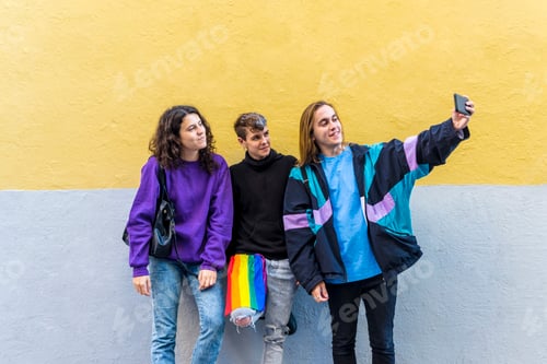 Preview: Young diverse friends taking selfies with a mobile phone outdoors.