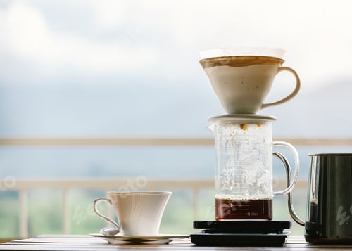 Preview: Cup of Dripping fresh hot coffee on the paper filter