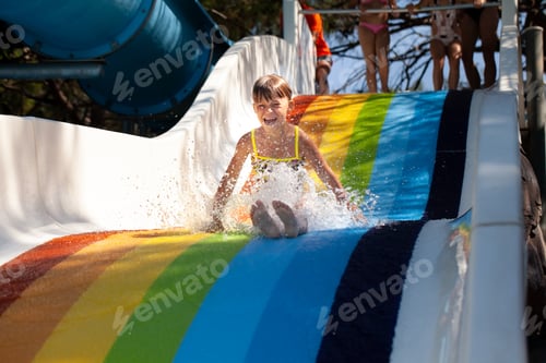 Preview: A little girl goes down the water slide and shouts cheerfully.