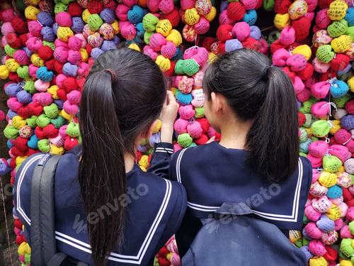 Preview: School girl taking photo of a colorful shrine in Kyoto
