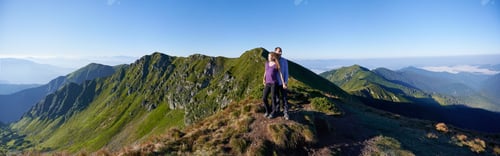 Preview: Woman and boyfriend on top of mountain.