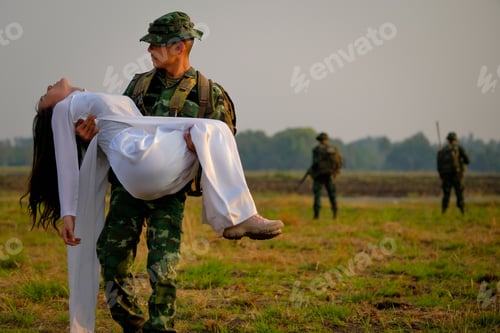 Preview: Soldier man carry Vietnamese woman in the field also have soldier team as background
