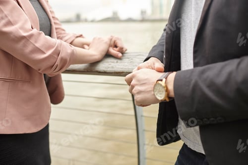 Preview: Mid section of businesswoman and businessman meeting on waterfront, London, UK