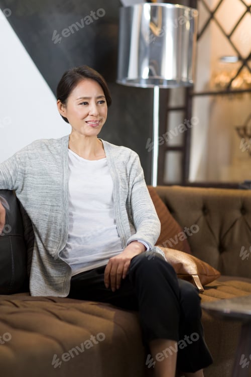 Preview: Mature woman sitting on sofa