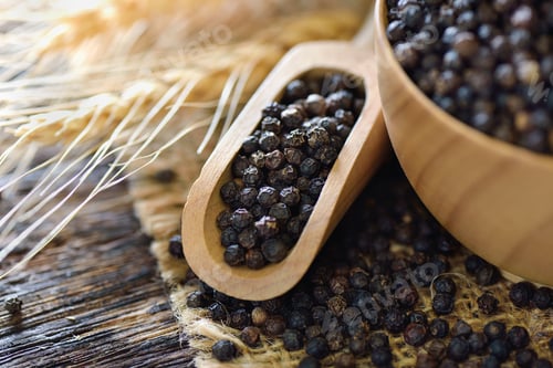 Preview: black pepper seeds in wood scoop on table