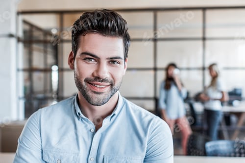 Preview: portrait of handsome young businessman smiling at camera in office