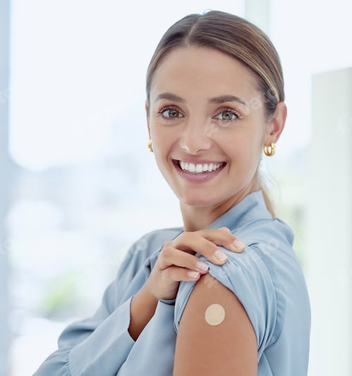 Preview: Portrait of woman with a plaster on her arm from vaccine or an injection. Young, smiling woman with