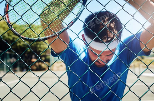 Preview: Cropped shot of a handsome young sportsman taking a moment to breathe during tennis practise