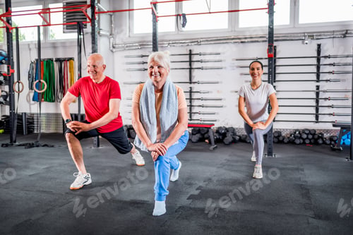 Preview: Personal trainer with senior couple doing rehab exercises at the gym