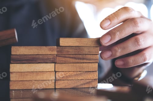 Preview: Closeup image of people playing and building wooden puzzle game