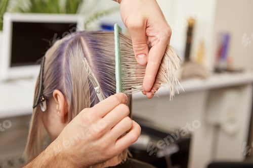 Preview: Hairdresser cutting blonde woman hair in beauty salon