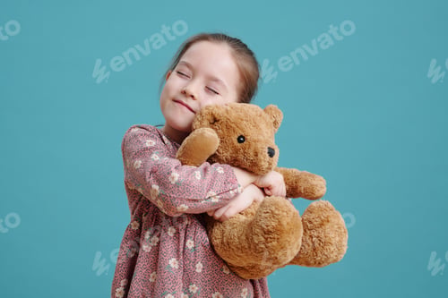 Preview: Happy cute little girl embracing her brown teddybear