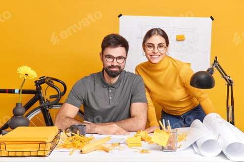 Preview: Woman and man developers create architect project use blueprints sketches look happily at camera aft