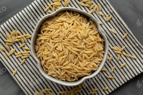 Preview: Raw Organic Orzo Pasta in a Bowl, top view. From above, overhead, flat lay.