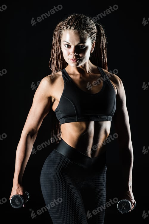 Preview: Beautiful slim woman with dumbbells, black background