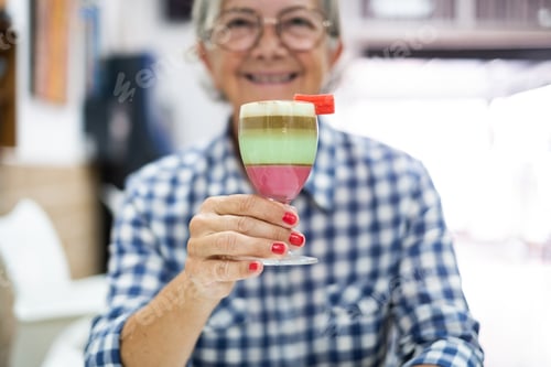 Preview: Smiling senior woman holding a local specialty of Canary island called barraquito
