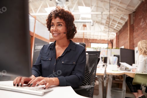 Preview: Female Customer Services Agent Working At Desk In Call Center