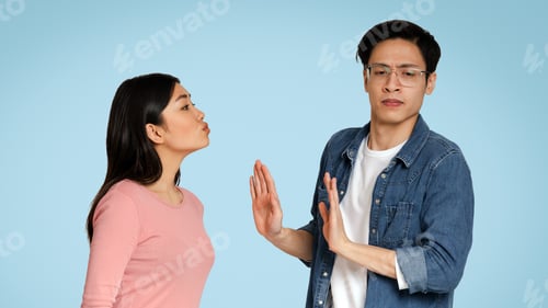 Preview: Autism And Relationships Concept. Concerned Autistic Guy Rejecting Kisses From Girlfriend