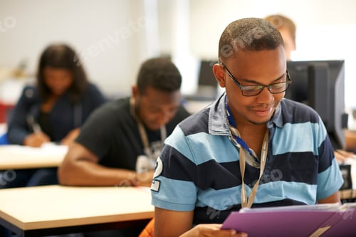 Preview: Male higher education student reading file in college classroom