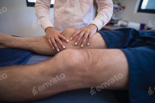 Preview: Female doctor massaging knee of patient