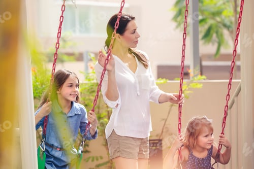 Preview: Mother with two daughters on playground