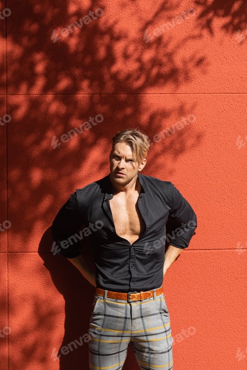 Preview: Muscular man posing against red wall