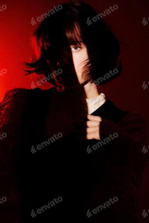 Preview: A woman with short hair is standing in front of a red background