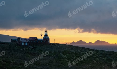 Preview: Beautiful shot of buildings and a lighthouse on a mountain under a cloudy sky at Cape Horn