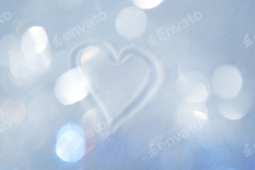 Preview: Defocused hand-drawn heart on snowy surface with warm glittering bokeh