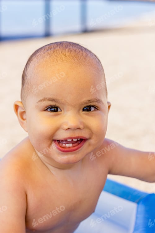 Preview: Happy smiling baby boy in an inflatable pool