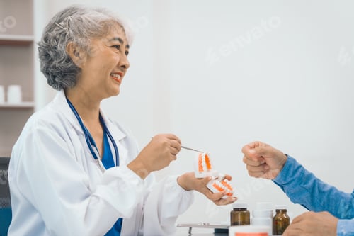 Preview: Asian people mature dentist having a compassionate conversation with elderly patient