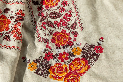 Preview: Ukrainian clothes embroidered shirt. Red orange and black threads background. Vyshyvanka is a symbol