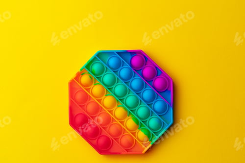 Preview: Colorful antistress pop it toy on yellow background