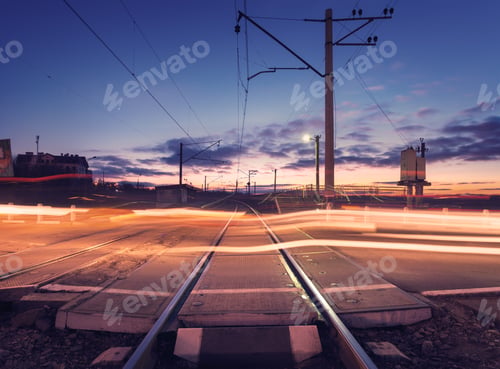 Preview: Railroad crossing with car lights in motion at night