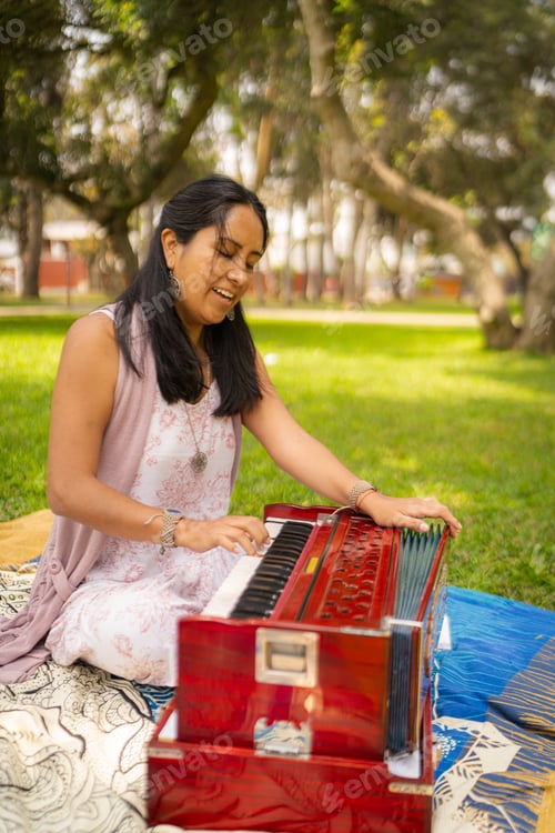 Preview: Happy woman playing her harmonium in the park