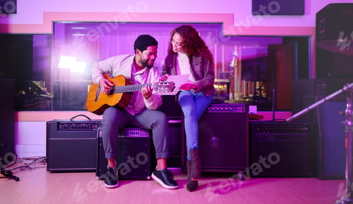Preview: Black man, woman and songwriting with guitar, studio and night with paper for creative lyrics, note