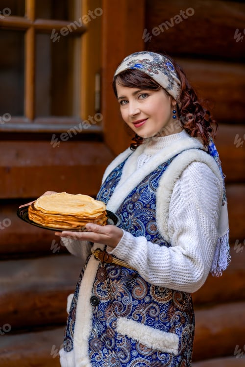 Preview: A woman is dressed in national Russian dress. She is holding a plate of pancakes and a wicker basket