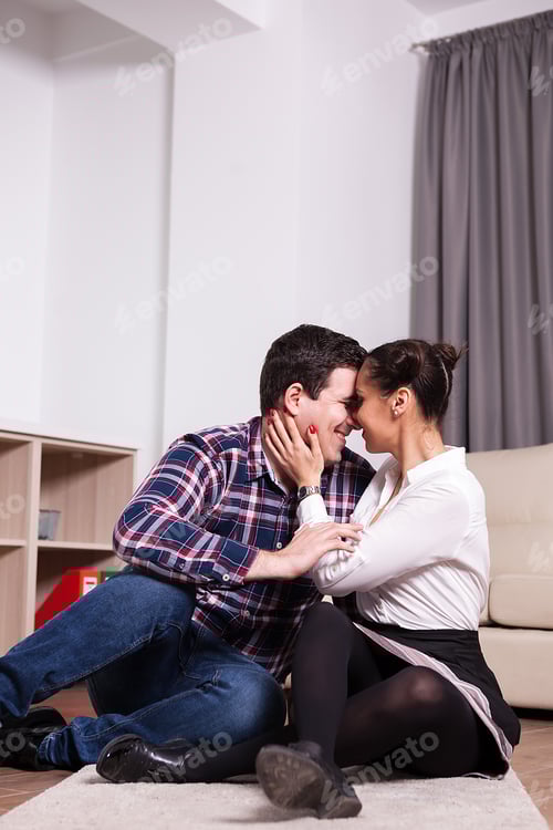 Preview: Romantic Couple Embracing Affectionately on Living Room Floor
