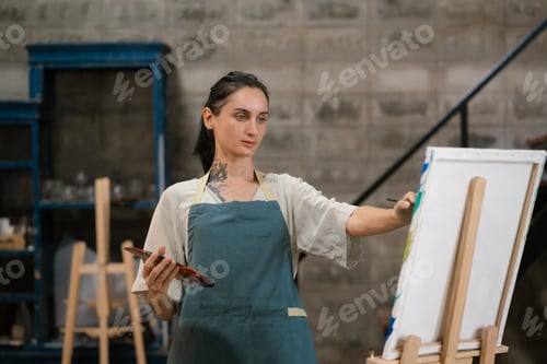 Preview: lifestyle female artist painting on canvas in the home studio.