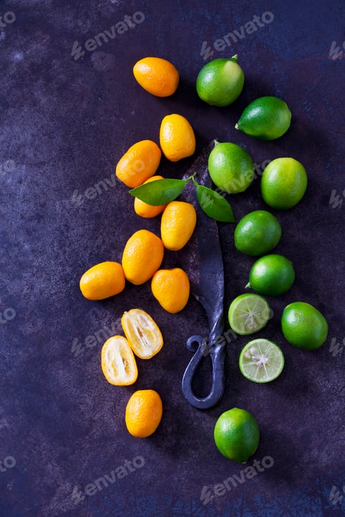 Preview: Sliced and whole kumquats, limequats, leaves and old knife on rusty ground
