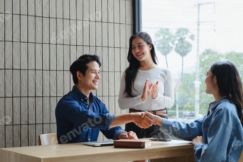 Preview: Asian businesspeople shaking hands during a meeting