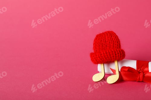 Preview: Note in a warm hat on a pink background.