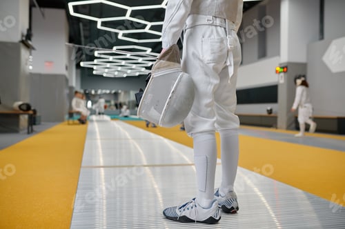 Preview: Cropped shot of young fencer wearing protective clothes holding helmet mask
