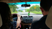 Preview: Female male couple, brother sister, taking a road trip - driver passenger from behind, windshield