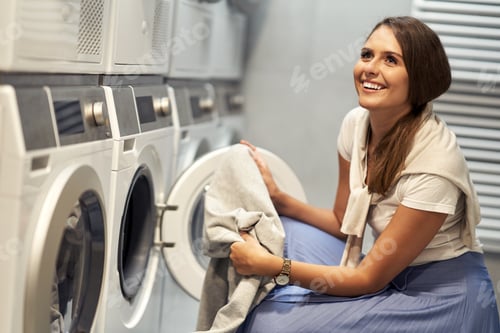 Preview: Smiling Woman Doing Laundry at Laundromat