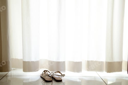 Preview: pair of sandals on floor under curtain