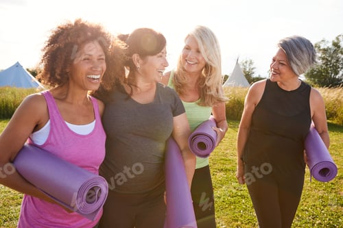 Preview: Group Of Mature Female Friends On Outdoor Yoga Retreat Walking Along Path Through Campsite