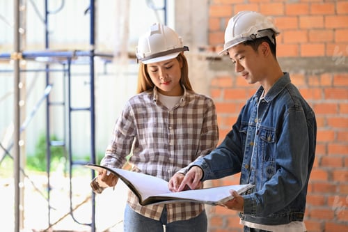 Preview: Young engineers supervising progress of construction project together.