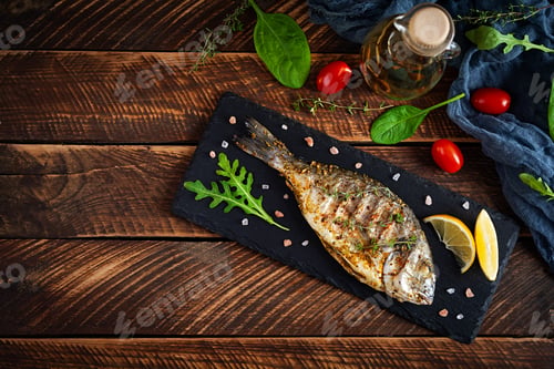 Preview: Grilled dorado fish on wooden background. Roasted seafish with spice and herbs